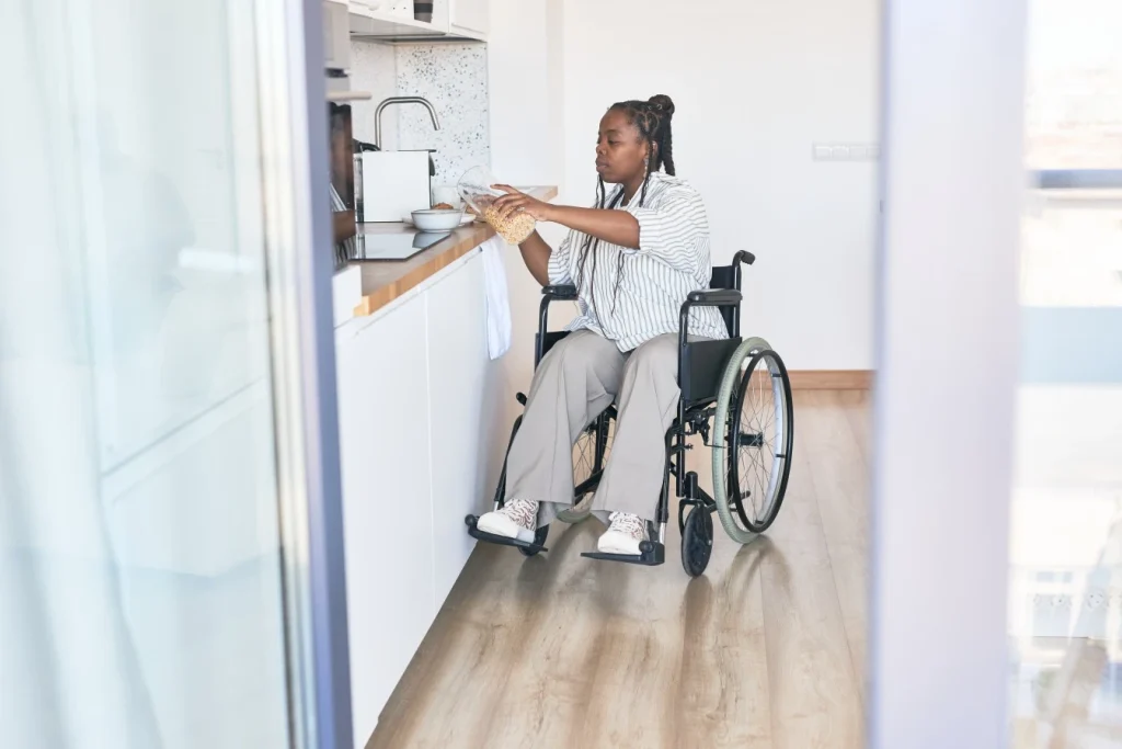 A disabled woman sitting in her wheelchair in the kitchen